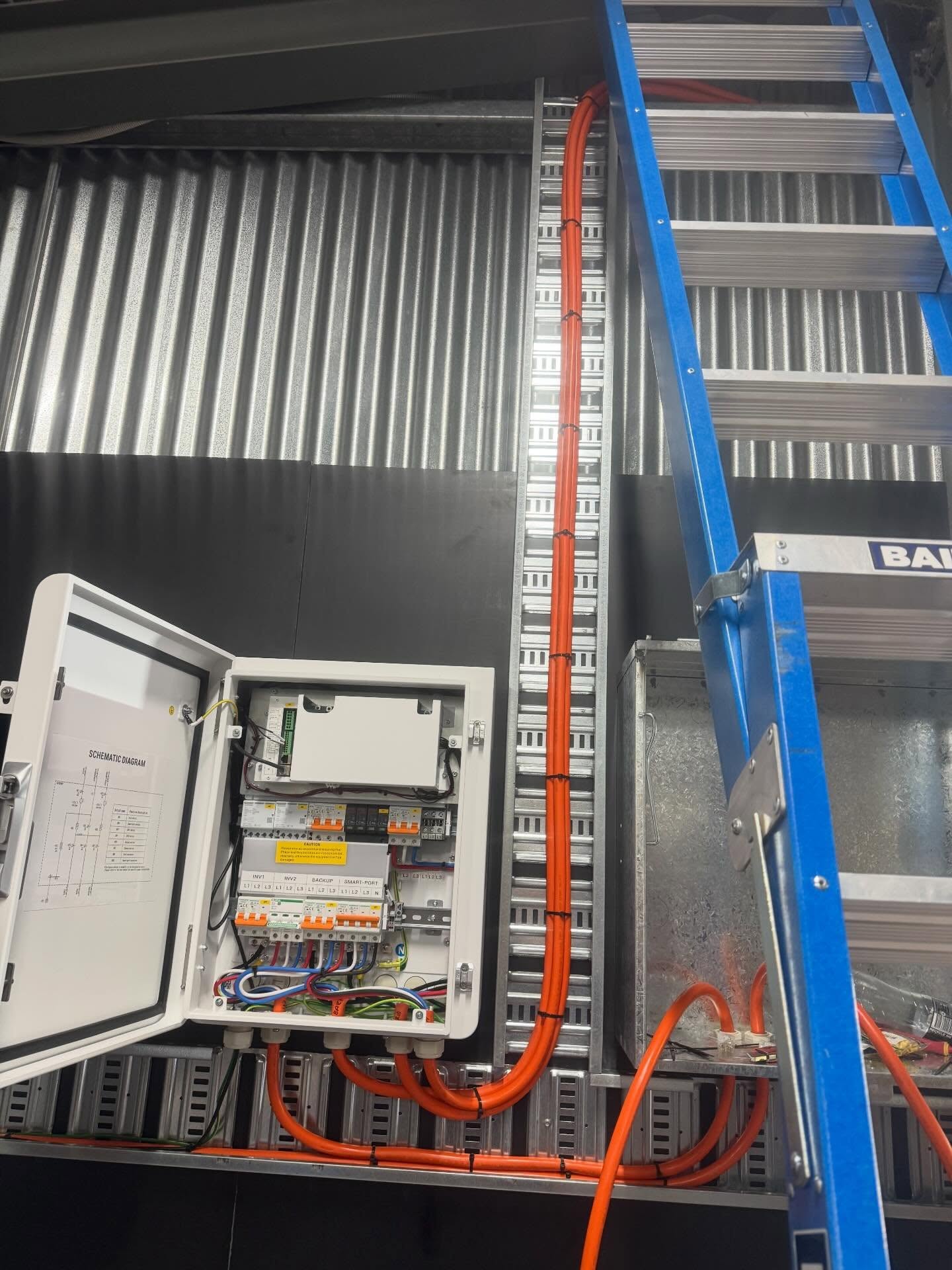 Emergency electrician's switchgear enclosure and orange cabling installed on a cable tray in Wagga Wagga